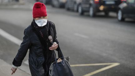 Une femme traverse la place Maillot, à Paris, le 23 janvier 2017, un jour de mesures antipollution dans la capitale.&nbsp; (GEOFFROY VAN DER HASSELT / AFP)