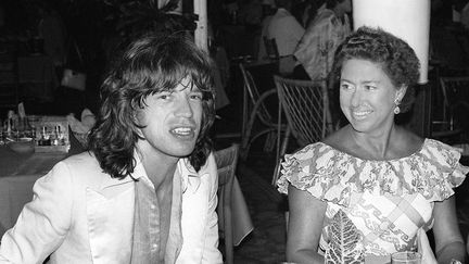 Mick Jagger contraste en compagnie de la princesse Margaret, la sœur de la reine Elisabeth II, en 1976. Mais après des années d'excès, la rock star sera finalement anoblie par la reine dans les années 2000 (par l'intermédiaire de son fils, Charles). Tous ces honneurs n'étaient pas du goût de Keith Richards, le guitariste du groupe, qui s'en est longtemps moqué. (JACQUES GUSTAVE / AFP)