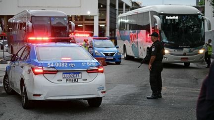 Des voitures de police stationnent devant la gare routière de Rio de Janeiro (Brésil) dans laquelle s'est déroulée une prise d'otages, le 12 mars 2024. (PABLO PORCIUNCULA / AFP)