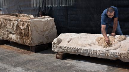 Les services d'archéologie israéliens nettoient un riche sarcophage romain exhumé, le 3 septembre 2015 à Bet Shemesh.
 (Menahem Kahana / AFP)