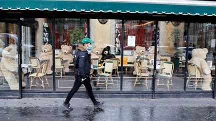 Un homme marche dans les rues de Paris avec un masque, le 15 mars 2021. (LUDOVIC MARIN / AFP)