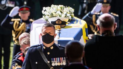Le cercueil du prince Philip était couvert de l'étendard personnel du duc d'Edimbourg, de son épée, sa casquette de la Marine et d'une couronne de fleurs. (DANNY LAWSON / POOL / AFP)