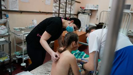 Des infirmières s'occupent à&nbsp;Zaporizhzhia&nbsp;d'une enfant de 13 ans touchée par une balle alors qu'elle était évacuée de Marioupol avec sa famille, le 22 mars 2022. (EMRE CAYLAK / AFP)