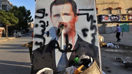 Affiche vandalisée du président Syrien Assad sur un tas de déchets à Alep (nord de la Syrie), le 24 juillet 2012. (AFP - BULENT KILIC)