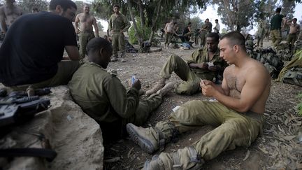 Des soldats isra&eacute;liens jouent aux cartes apr&egrave;s le retrait des troupes de Tsahal de la bande de Gaza,&nbsp;le 5 ao&ucirc;t 2014. (DAVID BUIMOVITCH / AFP)