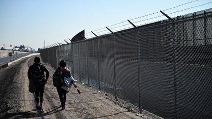 Deux jeunes migrants marchent le long de la frontière, à El Paso, au Texas, le 19 décembre 2022. (PATRICK T. FALLON / AFP)