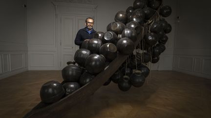 L'artiste indien Subodh Gupta a investi les salles et les cours de la Monnaie de Paris avec ses œuvres de métal (il s'inspire du quotidien en utilisant des ustensiles de cuisine), une tête de mort monumentale, des arbres. Des vidéos aussi où il parle de voyage et particulièrement de migrations. Il parle aussi de cinéma et tout simplement de convivialité. Jusqu'au 26 août. Ici, Subodh Gupta à la Monnaie de Paris, devant une de ses œuvres (("Jal Mein Kumbh, Khumbh Mein Jal Hai), le 5 avril 2018
 (Lionel Bonaventure / AFP)