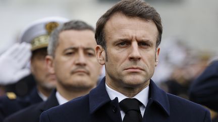 Le ministre de l'Intérieur Gérald Darmanin derrière le président de la République Emmanuel Macron à Versailles (Yvelines) le 31 mars 2023 (LUDOVIC MARIN / POOL / AFP POOL)