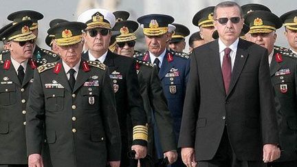 Le 30 novembre 2010, à Ankara, le Premier ministre turc Recep Tayyip Erdogan devant des membres du haut Conseil militaire. A sa gauche, le chef d'état-major général Isik Kosaner. Ce dernier et tout le haut commandement militaire devaient démissionner le 29 juillet 2011, à la suite d’un désaccord avec le gouvernement concernant les généraux emprisonnés pour un complot présumé. (AFP PHOTO / ADEM ALTAN)
