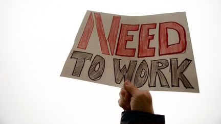 Une pancarte sur laquelle est écrit "besoin de travailler", lors d'une manifestation d'élus et d'employés fédéraux contre le "shutdown", le 8 janvier 2019, à Philadelphie, en Pennsylvanie (Etats-Unis).&nbsp; (MARK MAKELA / GETTY IMAGES NORTH AMERICA / AFP)