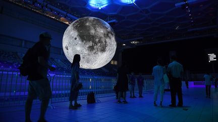 Une fausse Lune est exposée au dessus du bassin olympique du Centre national aquatique de Chine, à Pékin, le 11 juillet 2018. (GREG BAKER / AFP)