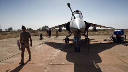 Un soldat fran&ccedil;ais marche pr&egrave;s d'un Mirage fran&ccedil;ais sur la base de Bamako (Mali), le 16 janvier 2013. (ERIC FEFERBERG / AFP)