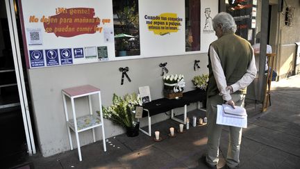 Un homme&nbsp;face à&nbsp;l'autel érigé devant la façade du restaurant de Baptiste Lormand, le 29&nbsp;novembre 2020, à Mexico. (CLAUDIO CRUZ / AFP)