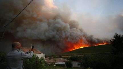 Un homme filme un incendie à Pietracorbara (Haute-Corse), le 11 août 2017. (PASCAL POCHARD-CASABIANCA / AFP)