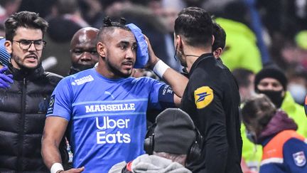 Dimitri Payet touché par un projectile dimanche 21 novembre au Groupama Stadium à Lyon. (PHILIPPE DESMAZES / AFP)