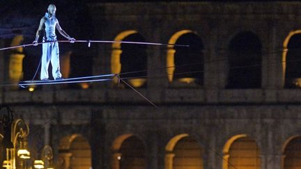 Le funambule Andrea Loreni exécute une performance devant le Colisée à Rome, au cours de la nuit blanche du 3 août 2013, pour fêter l'arrêt de la circulation autour du monument.
 (GABRIEL BOUYS / AFP)