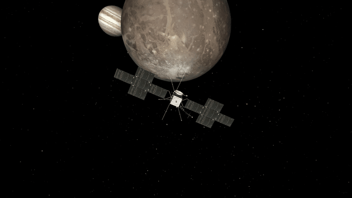 La sonde JUICE à proximité de Ganymède (la cible principale de la mission) avec, en fond, la planète géante Jupiter. (Illustration, vue d'artiste) (ESA)