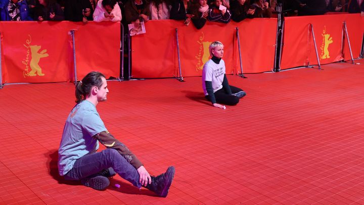 Deux jeunes activites se collent les mains avec de la glue sur le tapis rouge de la Berlinale, le 16 février 2023. (JORG CARSTENSEN / DPA / AFP)