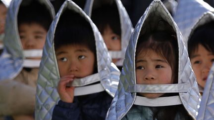 Des &eacute;coliers participent &agrave; un exercice de simulation d'un s&eacute;isme &agrave; Tokyo (Japon), le 11 mars 2014. (YUYA SHIHO / REUTERS)