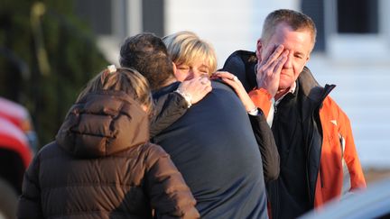 Des parents h&eacute;b&eacute;t&eacute;s, accroch&eacute;s &agrave; leur t&eacute;l&eacute;phone portable, des enfants en larmes et des autorit&eacute;s traumatis&eacute;es : la petite ville tranquille de Newtown a plong&eacute; dans l'horreur.&nbsp; (DON EMMERT / AFP)