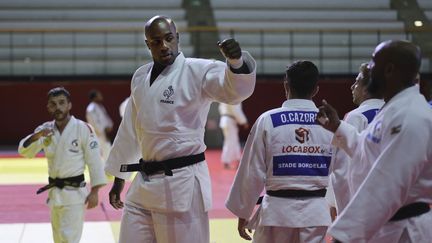 Teddy Riner salue ses coéquipiers avant de participer à un entraînement avec d'autres judokas français qualifiés pour les Jeux olympiques de Tokyo, à Paris, le 22 juin 2021. (THOMAS COEX / AFP)