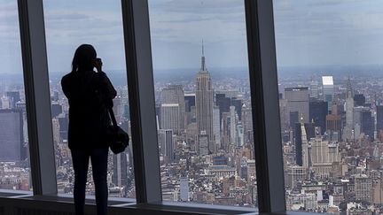 &nbsp; (Une femme photographie Manhattan depuis le centième étage de la tour One World Trade center à New York le 20 mai 2015. © REUTERS/Mike Segar)