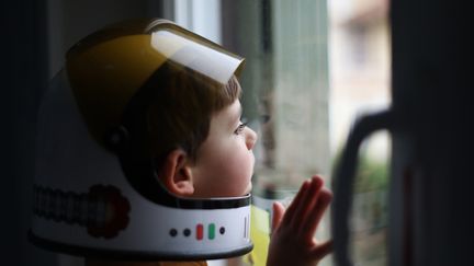 Un garçon de 4 ans et son casque de cosmonaute. Les générations à venir connaîtront un monde de l'emploi très automatisé. (Illustration) (CATHERINE DELAHAYE / DIGITAL VISION / GETTY IMAGES)