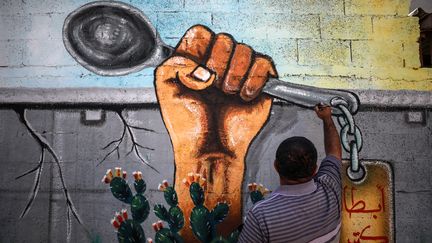 Un artiste dessine une cuillère, devenue symbole de la liberté après l'évasion de détenus palestiniens d'une prison israëlienne grâce à cet ustensile, à Gaza, le 18 septembre 2021. (MAJDI FATHI / NURPHOTO)