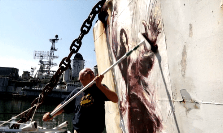 Paul Bloas colle une peinture sur une épaves de navire de guerre
 (France 3 culturebox)