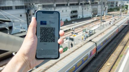 Un homme montre un pass sanitaire devant la gare de Rennes, le 21 juillet 2021. (EMILE KEMMEL / MAXPPP)