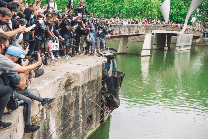 Des manifestants jettent à l'eau une statue du marchand d'esclaves Edward Colston, à Bristol, le 7 juin 2020. (GIULIA SPADAFORA / NURPHOTO / AFP)