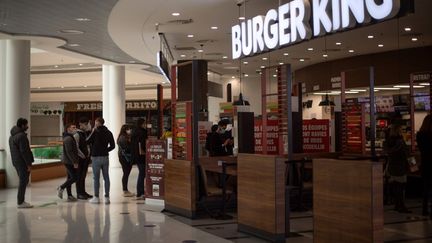 Des personnes font la queue devant une enseigne Burger King, au centre commercial de Saint-Herblain (Loire-Atlantique), le 13 janvier 2021. (LOIC VENANCE / AFP)