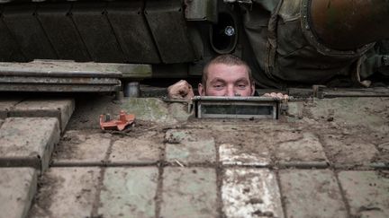 Un militaire de l'arm&eacute;e ukrainienne jette un &oelig;il hors de son tank pr&egrave;s du village de Peski, dans la r&eacute;gion de Donetsk (Ukraine), le 16 f&eacute;vrier 2015. (OLEKSANDR RATUSHNIAK / AFP)