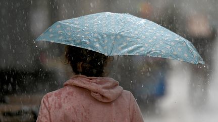 Une passante se protège de la pluie, le 28 octobre 2021, à Montpellier (Hérault). (PASCAL GUYOT / AFP)