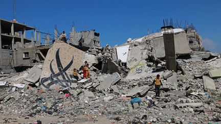 Des enfants jouent dans les ruines d'un bâtiment à Rafah, dans la bande de Gaza, le 22 février 2024. (MOHAMMED ABED / AFP)