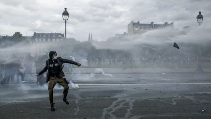 Un militant&nbsp;lance un projectile vers les forces de l'ordre, lors de la manifestation contre la loi Travail à Paris, le 14 juin 2016. (MICHAEL BUNEL / NURPHOTO / AFP)