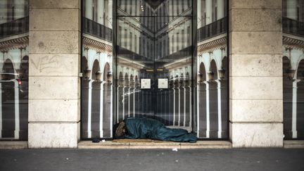 Une personne sans abri dort dans la rue, à Paris le 7 décembre 2017. (LIONEL BONAVENTURE / AFP)