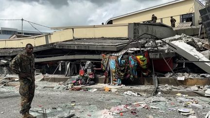 Un homme se tient devant un bâtiment effondré à Port-Vila (Vanuatu) après un séisme de magnitude 7,3, le 17 décembre 2024. (MICHAEL THOMPSON / AFP)