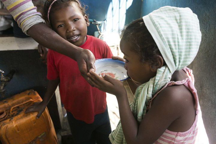 Petite fille buvant de l'eau près d'une fontaine publique à Antananarivo le 17 mars 2017. (AFP - RIJASOLO)