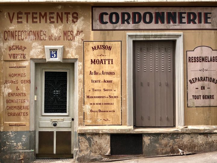 Les devantures de magasins, décors d'un film dont le tournage est stoppé durant le confinement, figent deux rues de Montmartre, à Paris, dans une ambiance de Seconde guerre mondiale.&nbsp; (MATTHIEU MONDOLONI / RADIO FRANCE)