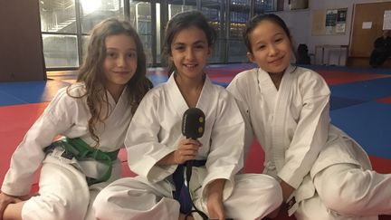 Joséphine, Camille et Yu pratiquent le karaté au centre sportif Jean Talbot, à Paris. (INGRID POHU / RADIO FRANCE)