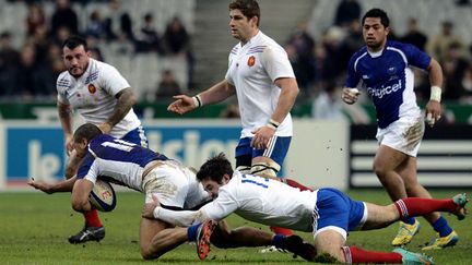 David Lemi (Samoa) retenu par Florian Fritz sous le regard de Pascal Papé (XV de France) (FRANCK FIFE / AFP)