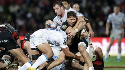 Le demi de mêlée toulousain Antoine Dupont au milieu de la défense clermontoise, le 12 octobre 2024 au stade Eernest-Wallon de Toulouse lors du match du Top 14. (VALENTINE CHAPUIS / AFP)