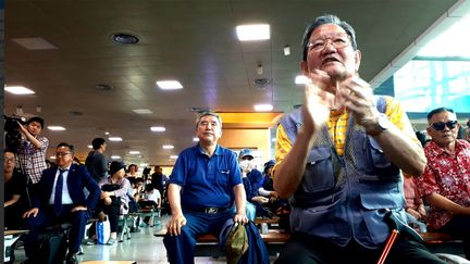 Des habitants de Séoul à la gare, regardant le sommet historique de Singapour à la télévision, le 12 juin 2018. (BENJAMIN ILLY / FRANCEINFO)