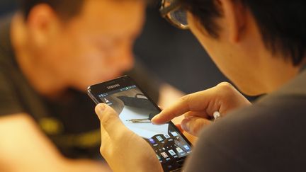 Un jeune Cor&eacute;en consulte un smartphone, &agrave; S&eacute;oul (Cor&eacute;e du Sud), le 6 juillet 2012. (LEE JAE WON / REUTERS)