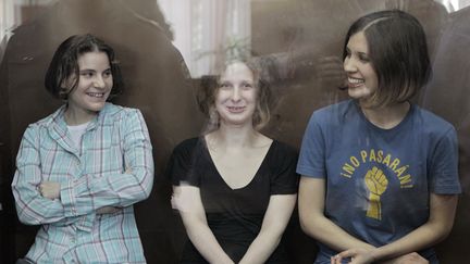 Les trois jeunes femmes du groupe punk russe Pussy Riot sourient &agrave; l'&eacute;nonc&eacute; de leur jugement, le 17 ao&ucirc;t 2012 &agrave; Moscou (Russie). (ANDREY STENIN / RIA NOVOSTI / AFP)