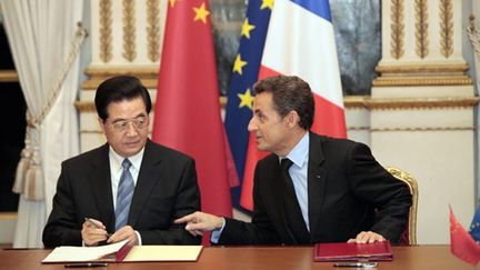 Les présidents Sarkozy et Hu Jintao en train d'assister à la signature de contrats commerciaux (AFP - POOL THIBAULT CAMUS)