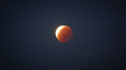 Un photographe capture une "super Lune", à l'occasion d'une éclipse lunaire totale, le 26 mai 2021 depuis les Philippines. (RYAN EDUARD BENAID / NURPHOTO / AFP)