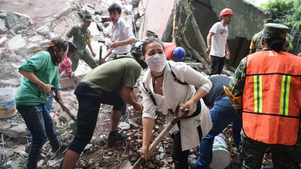 Des habitants de Mexico (Mexique) fouillant les décombres d'un immeuble effondré, le 19 septembre 2017.&nbsp; (RONALDO SCHEMIDT / AFP)