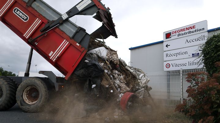 Des agriculteurs d&eacute;versent des d&eacute;chets devant une entreprise de distribution, &agrave; Villers-Bocage (Calvados), le 19 juillet 2015. (CHARLY TRIBALLEAU / AFP)